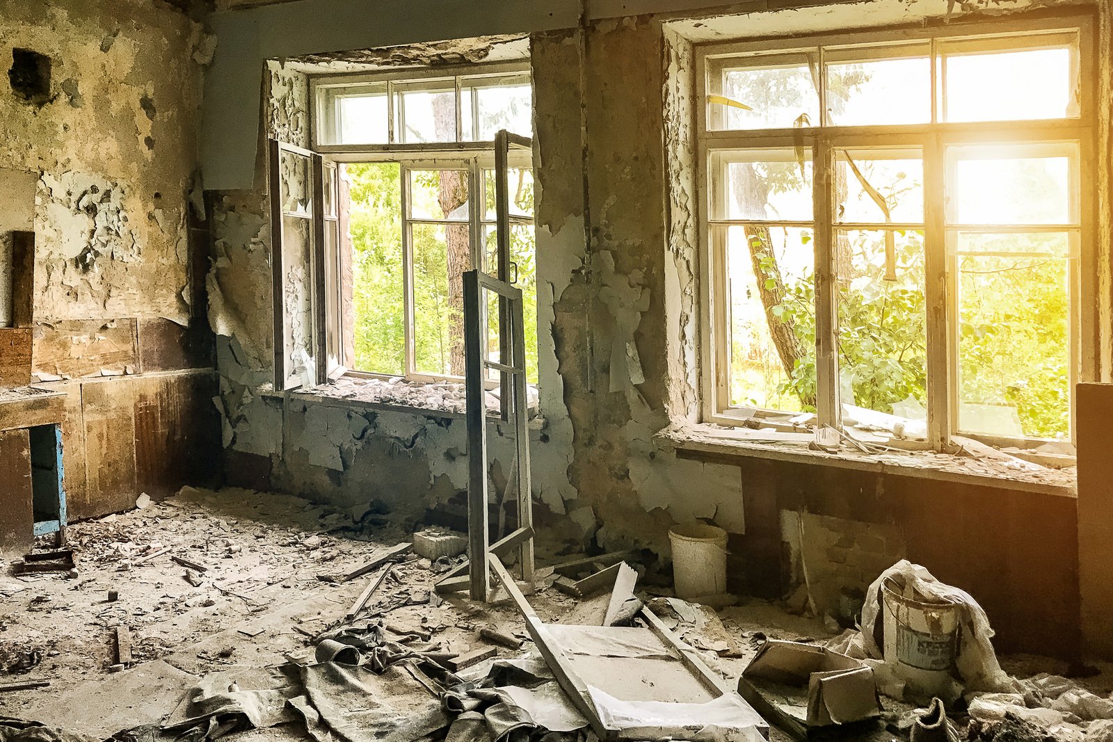 A water-damaged room with sunlight streaming through the window during restoration